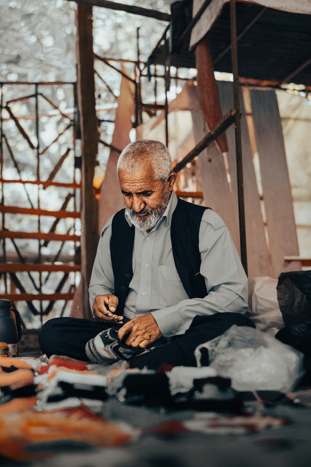 Photographer documenting an elderly craftsman in his workshop